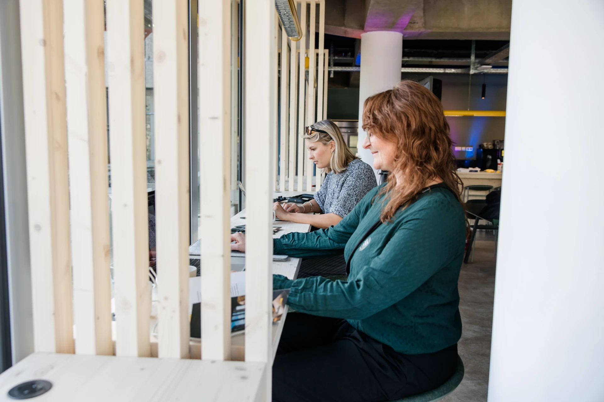 Zwei Personen sitzen arbeitend an Laptops im studio_one-Open Space