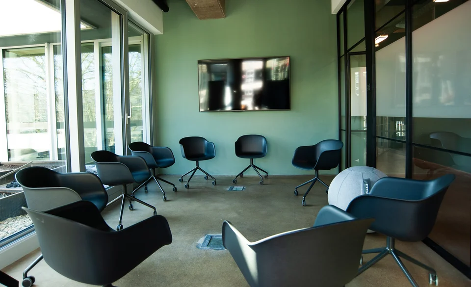 Großer Meetingraum "Sunset" im studio_one mit Stuhlkreis und einem Fernseher an der Wand