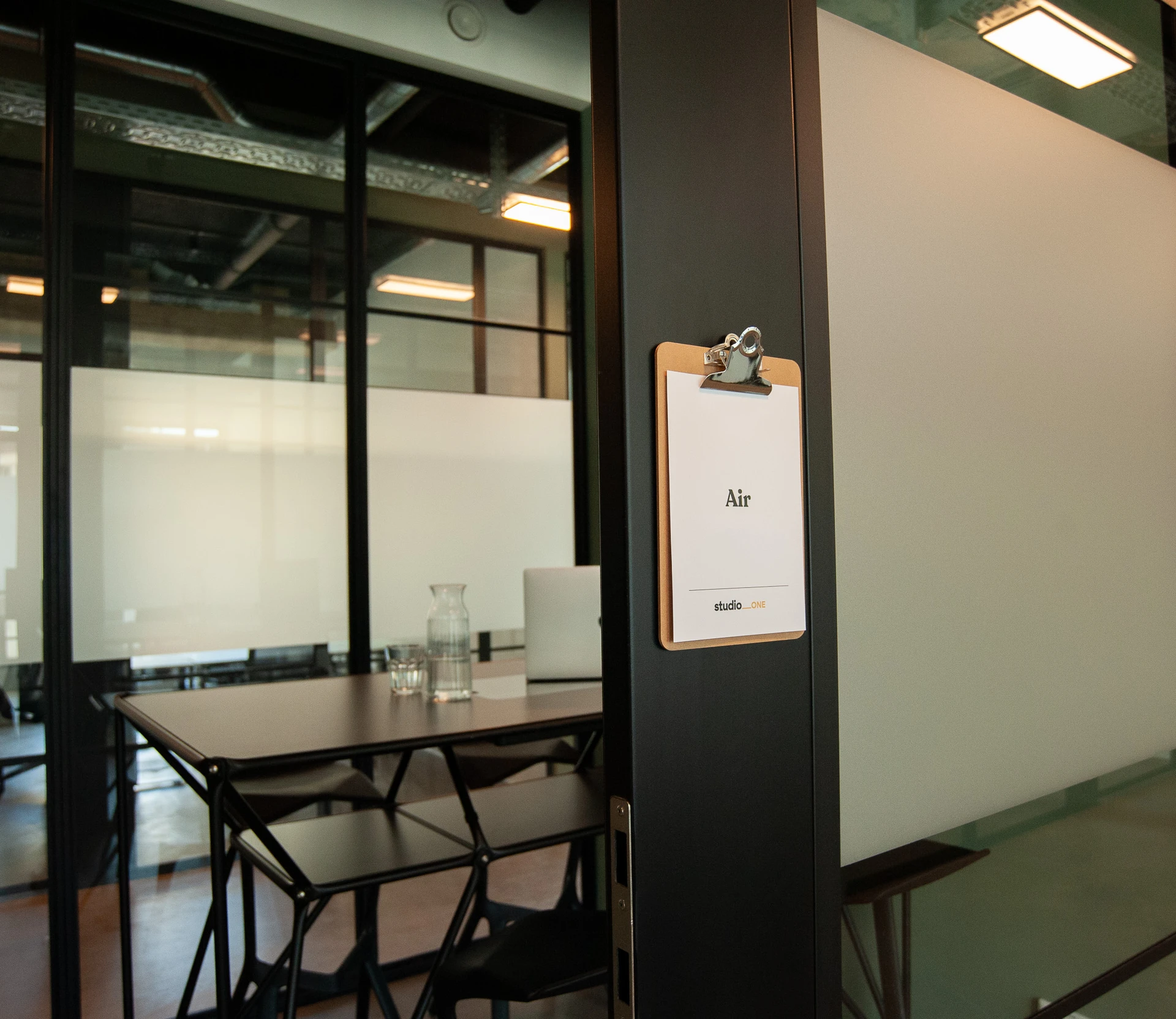 Schild mit Raumname vor kleinem Meetingraum "Air" im studio_one