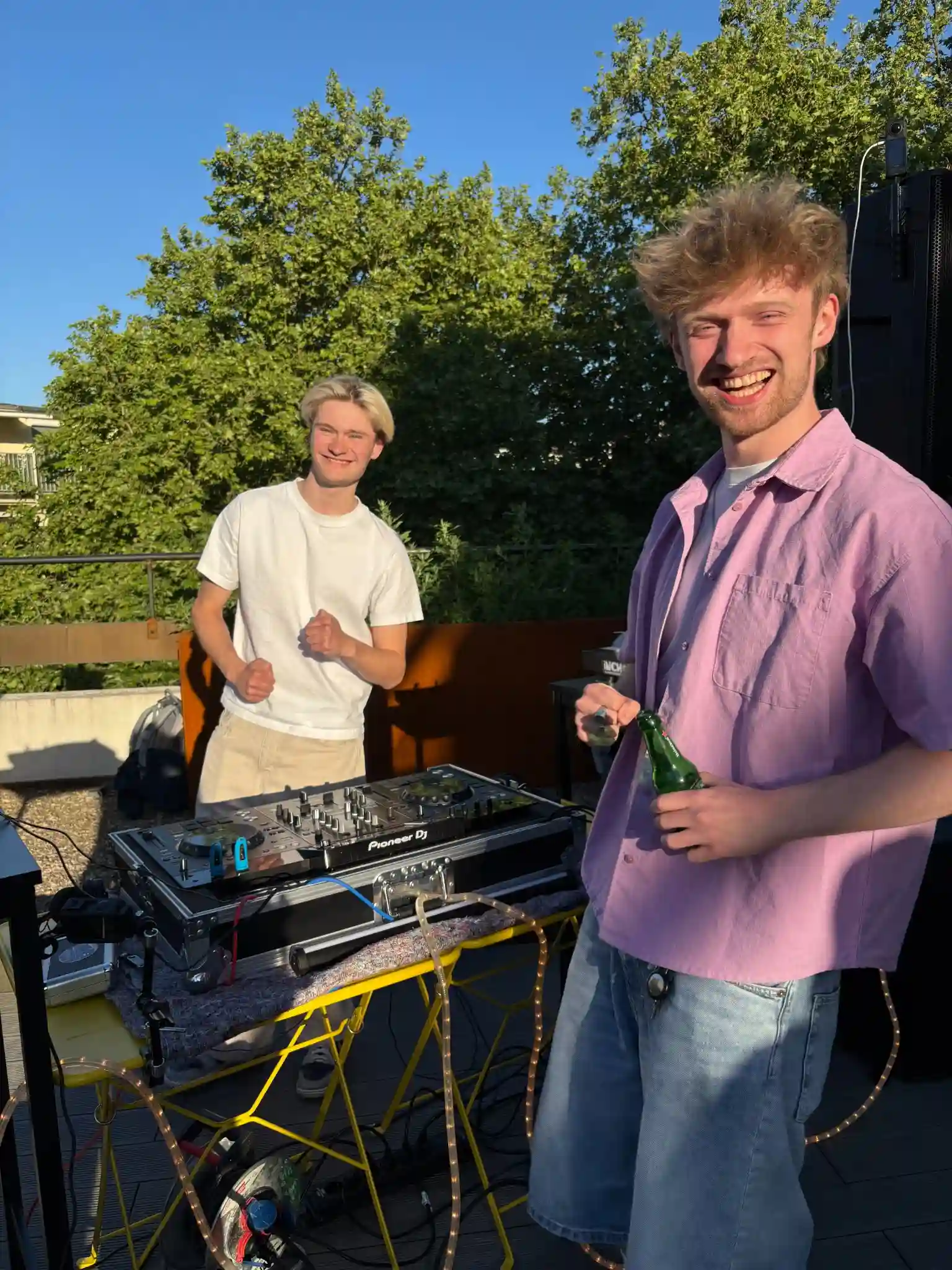 Zwei junge DJs erfreuen sich über eine erfolgreiche Afterwork-Party auf der studio_one-Dachterrasse